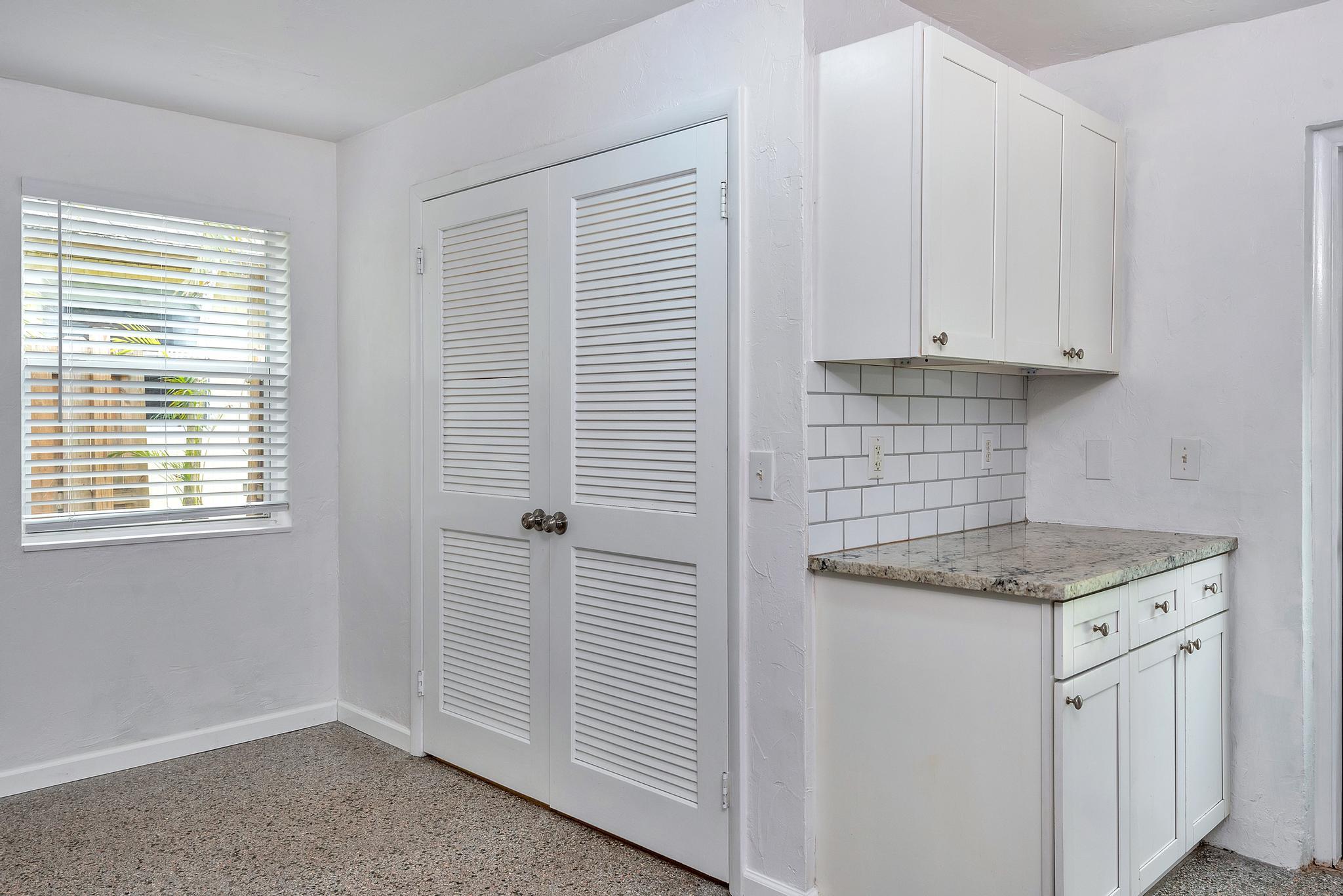 4882 Jefferson Road Delray Beach, FL 33445 - Photo 12 of 41 a kitchen with granite countertop white cabinets and white appliances