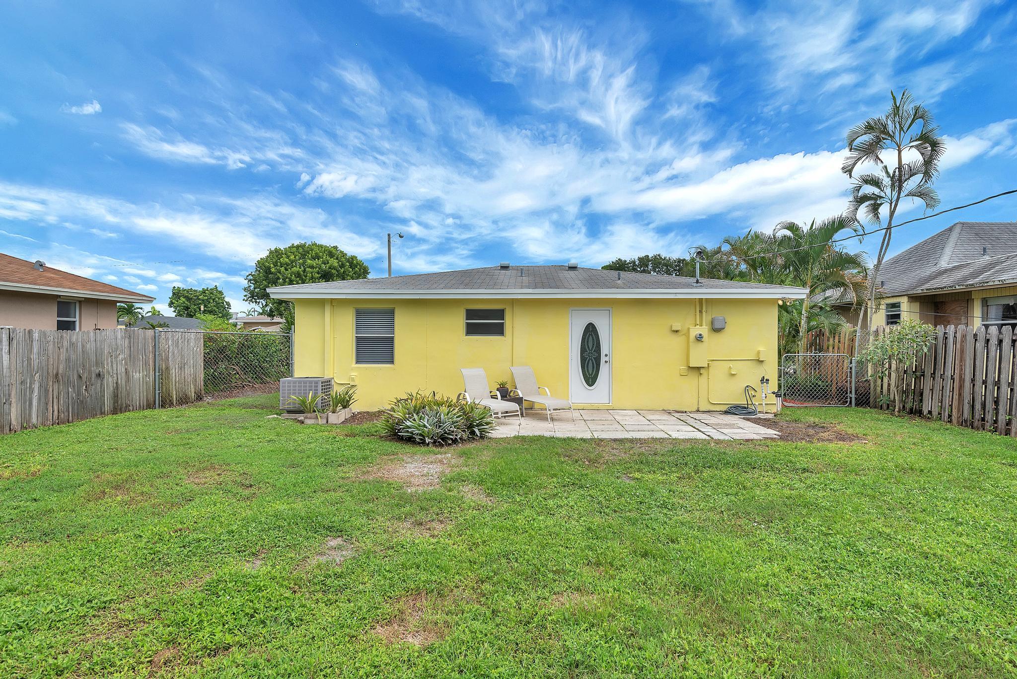 4882 Jefferson Road Delray Beach, FL 33445 - Photo 31 of 41 a view of a backyard with table and chairs and wooden fence