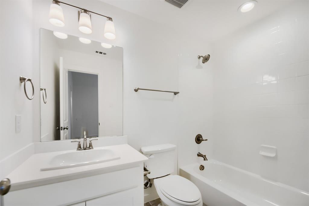 11465 Wulstone Road Fort Worth, TX 76052 - Photo 25 of 27 Bathroom featuring a white vanity with an integrated sink, polished chrome faucet, and a rectangular wall-mounted mirror