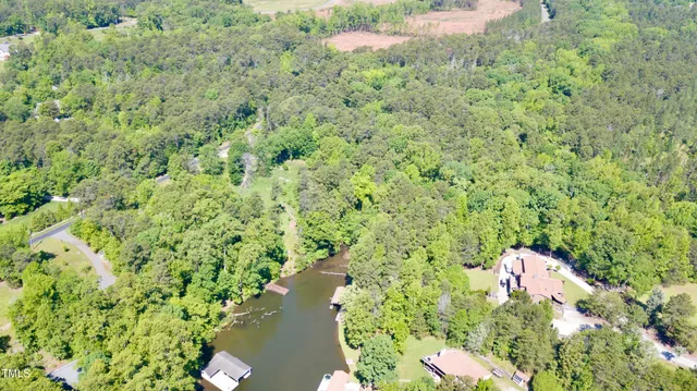 a view of a yard with plants and wooden fence