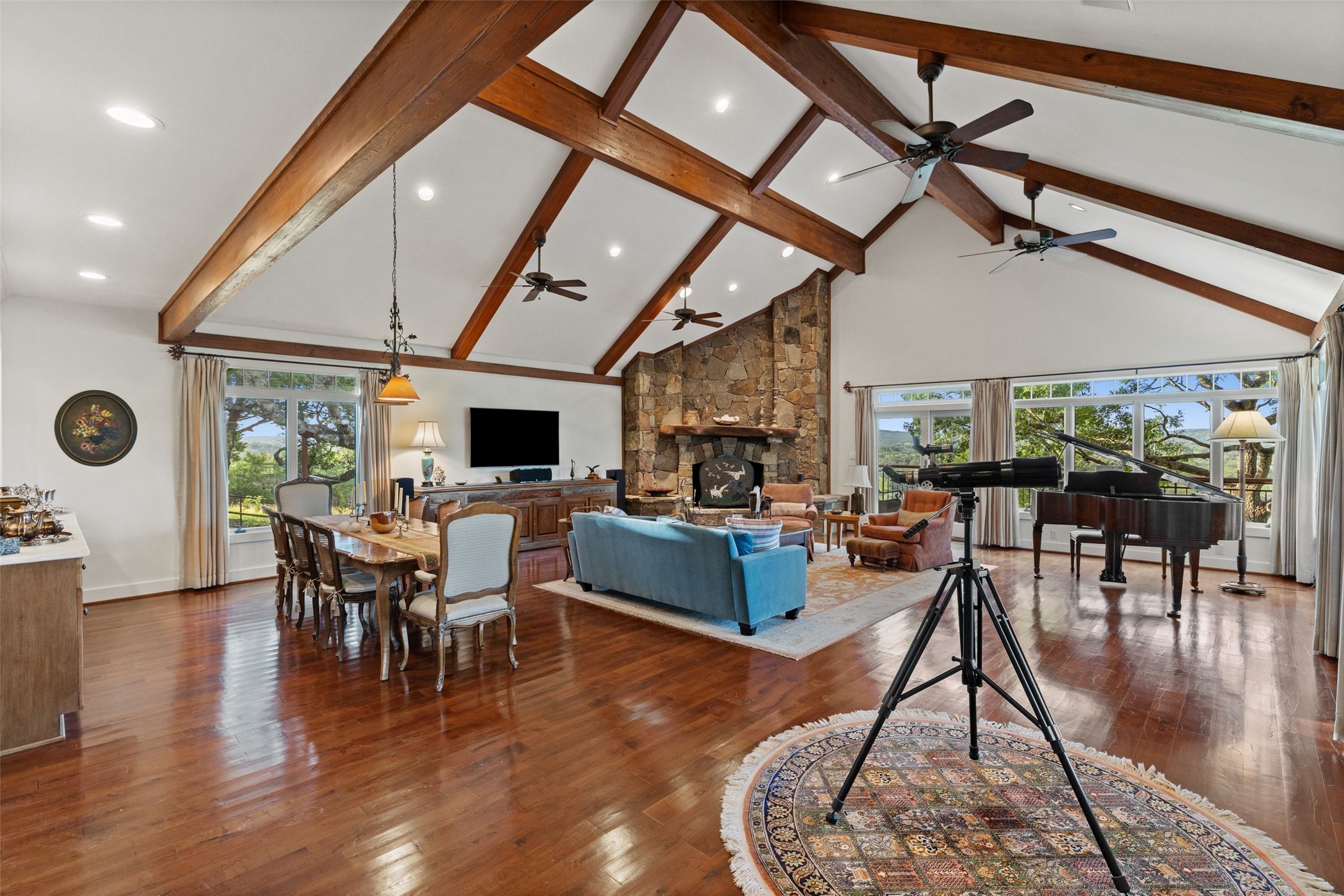 505 Red Corral Ranch Road Wimberley, TX 78676 - Photo 32 of 40 Gleaming hardwood floors and high vaulted ceilings create an inviting, open-concept living and dining space, anchored by a commanding stone fireplace.