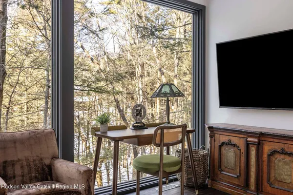 a living room with furniture a large window and a flat screen tv