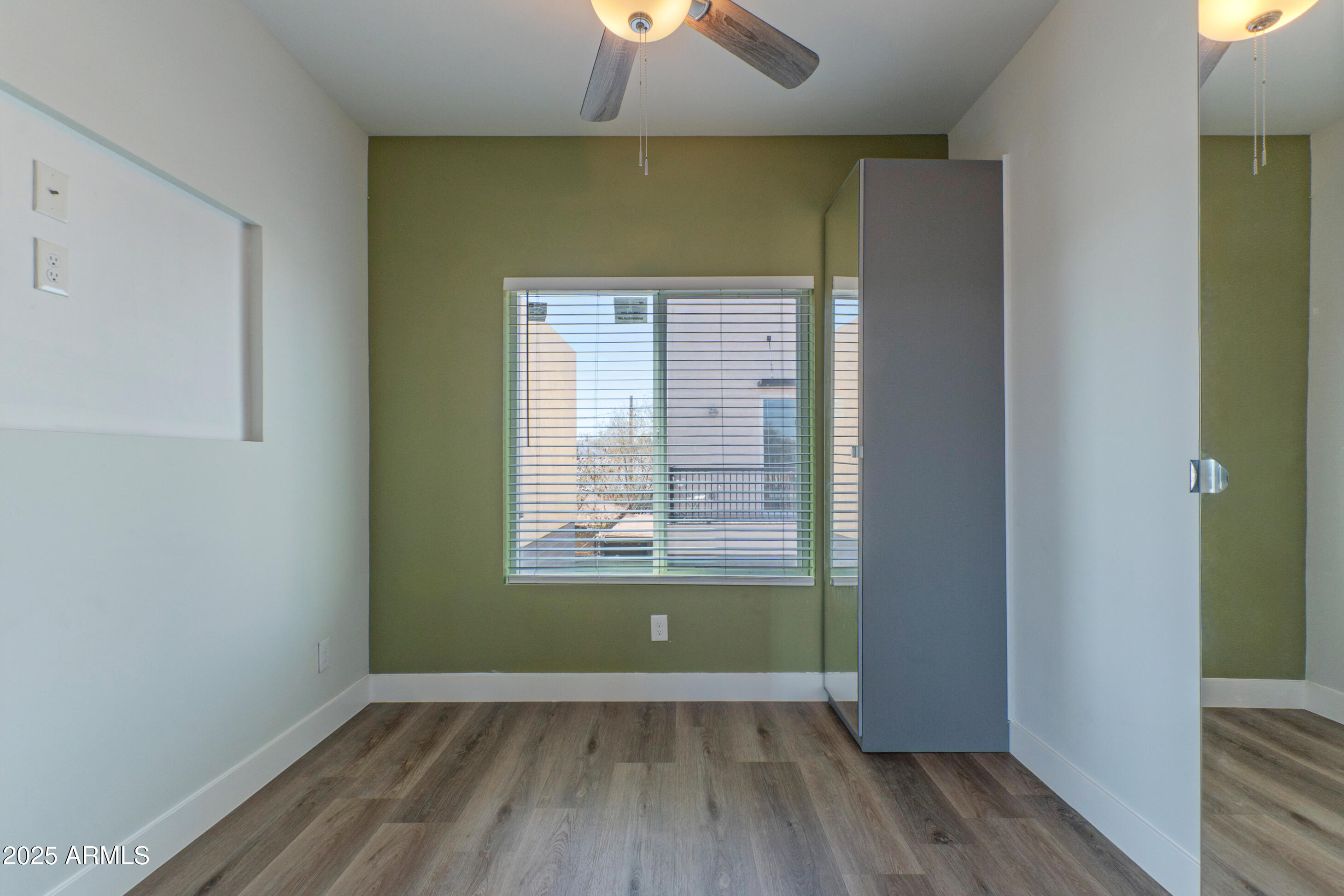 1106 South Montezuma Avenue Phoenix, AZ 85003 - Photo 11 of 15 an empty room with wooden floor closet and windows