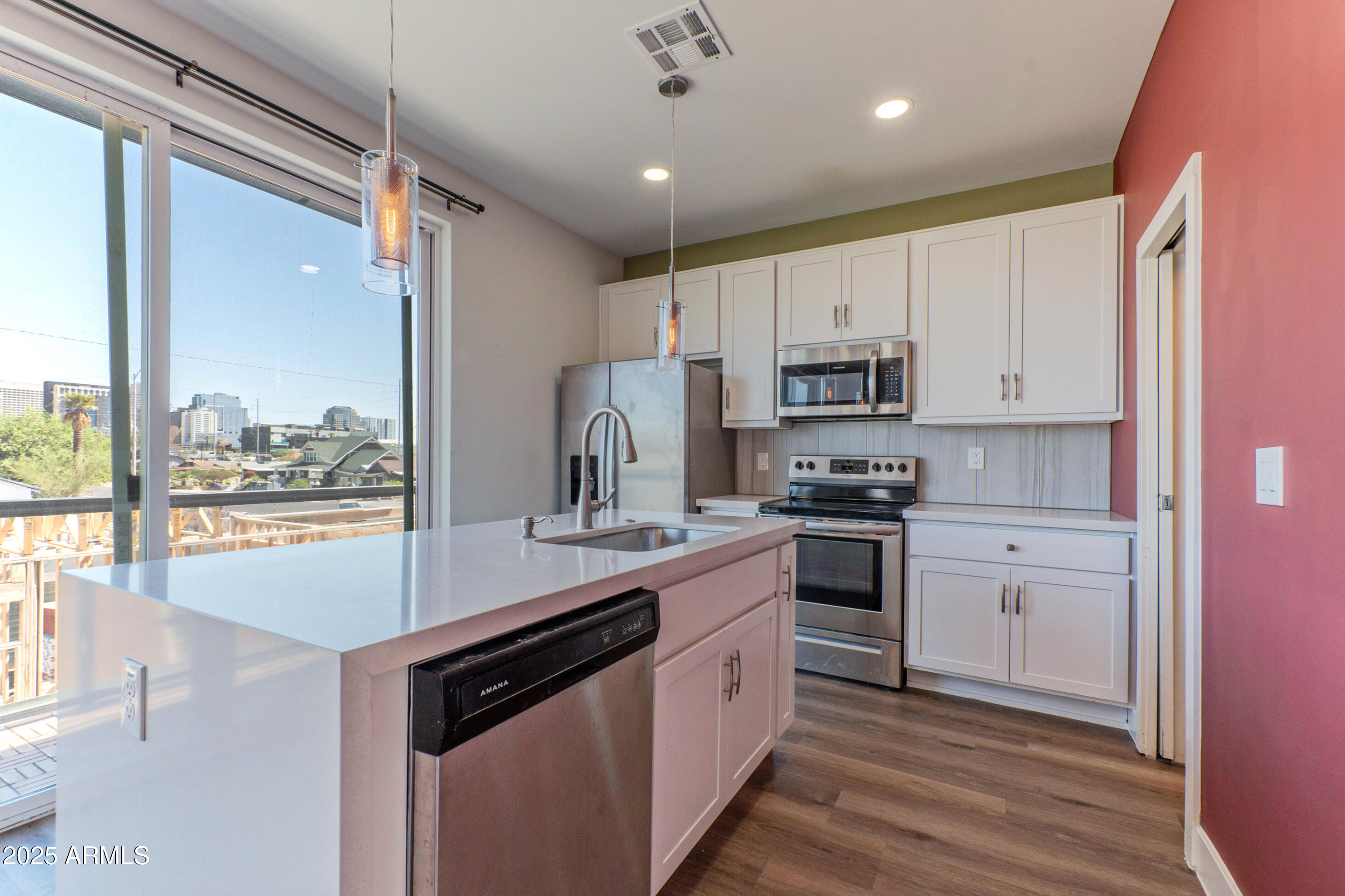 1106 South Montezuma Avenue Phoenix, AZ 85003 - Photo 12 of 15 a kitchen with kitchen island granite countertop a stove cabinets and a refrigerator