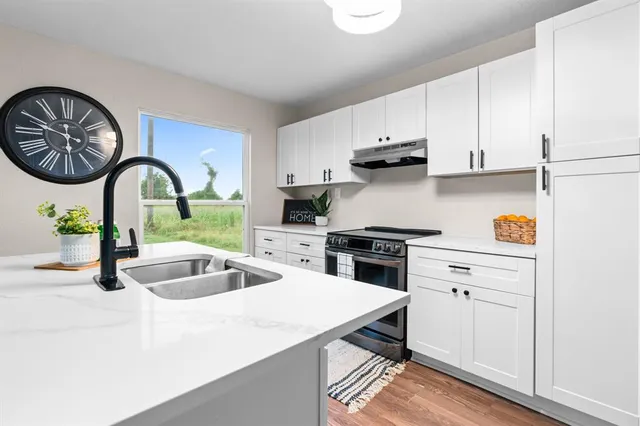 a kitchen with white cabinets and stainless steel appliances