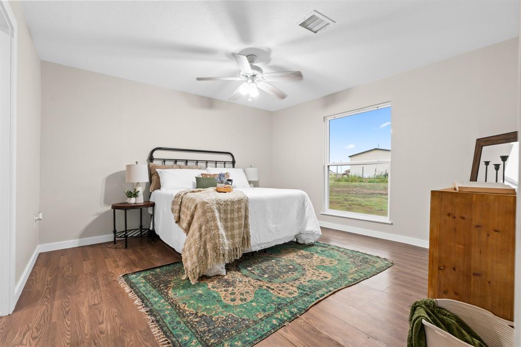 175 Hcr-4434 Itasca, TX 76055 - Photo 10 of 30 a bedroom with a bed and a dresser with wooden floor