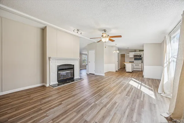 a view of empty room with wooden floor and fireplace