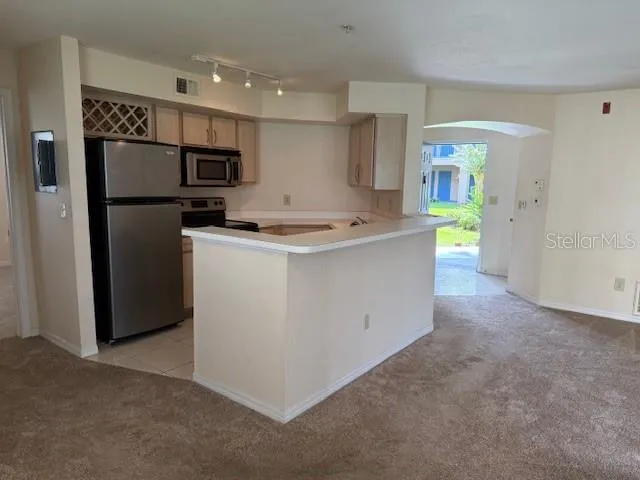 a kitchen that has a sink and a refrigerator in it