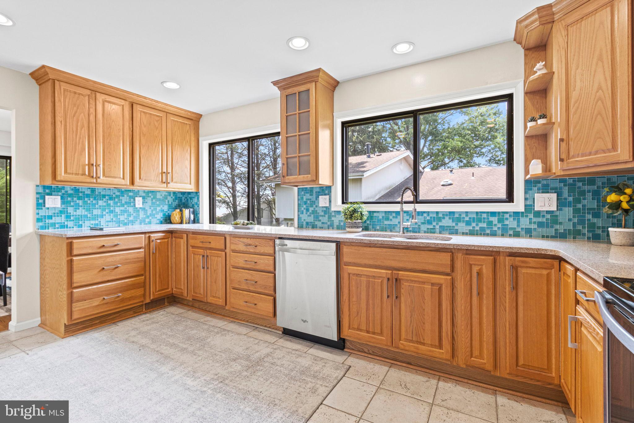 9712 Eldwick Way Potomac, MD 20854 - Photo 14 of 63 a kitchen with granite countertop wooden cabinets stainless steel appliances a large window and a sink
