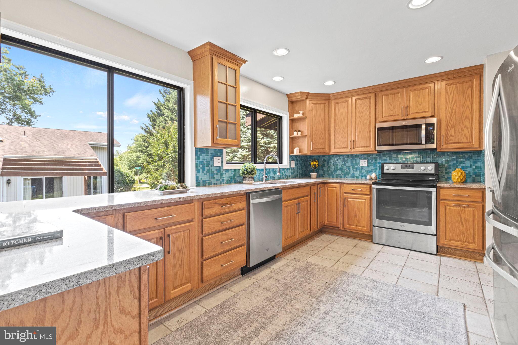 9712 Eldwick Way Potomac, MD 20854 - Photo 15 of 63 a kitchen with stainless steel appliances granite countertop a stove a sink and a microwave