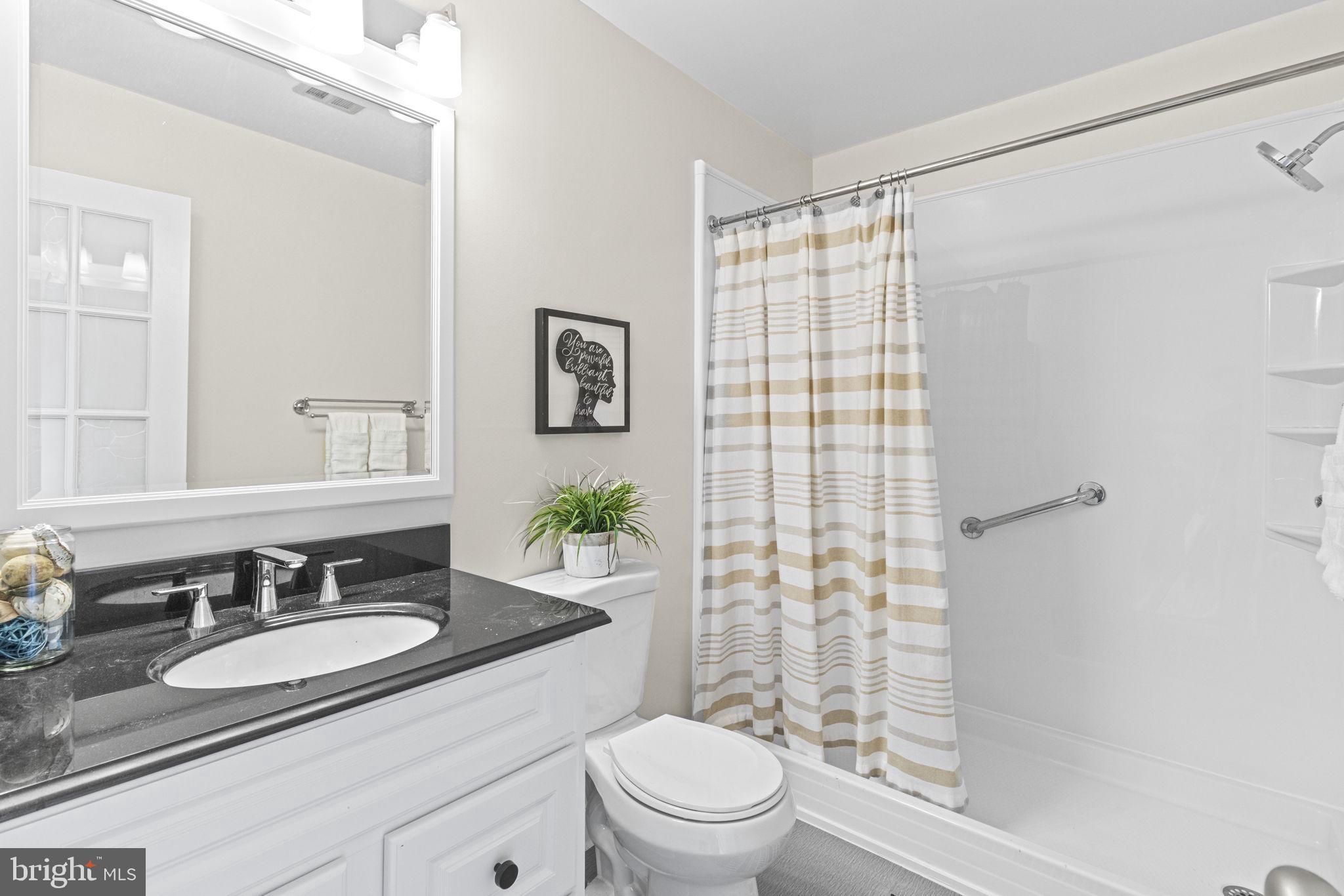 9712 Eldwick Way Potomac, MD 20854 - Photo 26 of 63 a bathroom with a sink toilet a mirror and shower