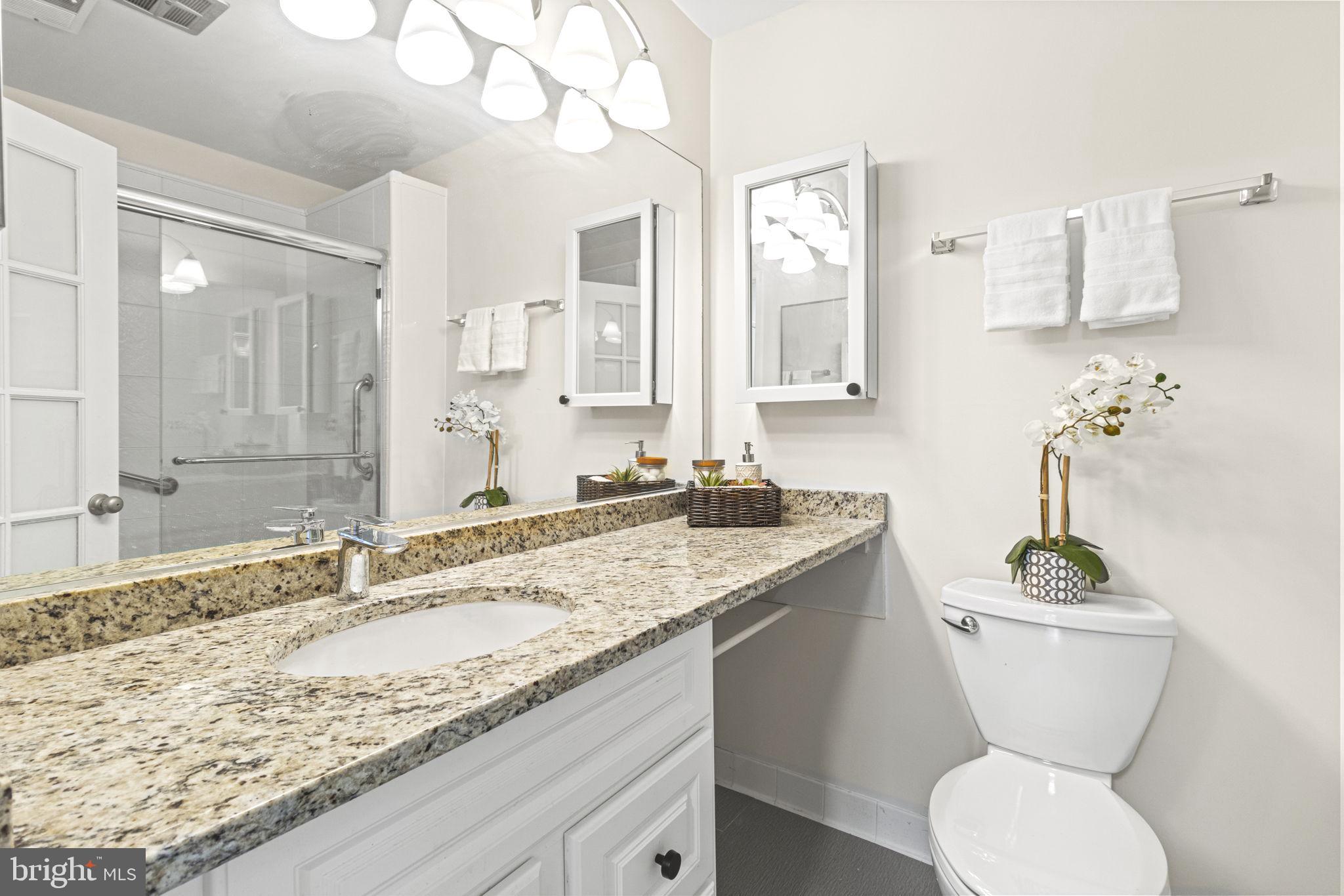 9712 Eldwick Way Potomac, MD 20854 - Photo 31 of 63 a bathroom with a granite countertop sink mirror and toilet
