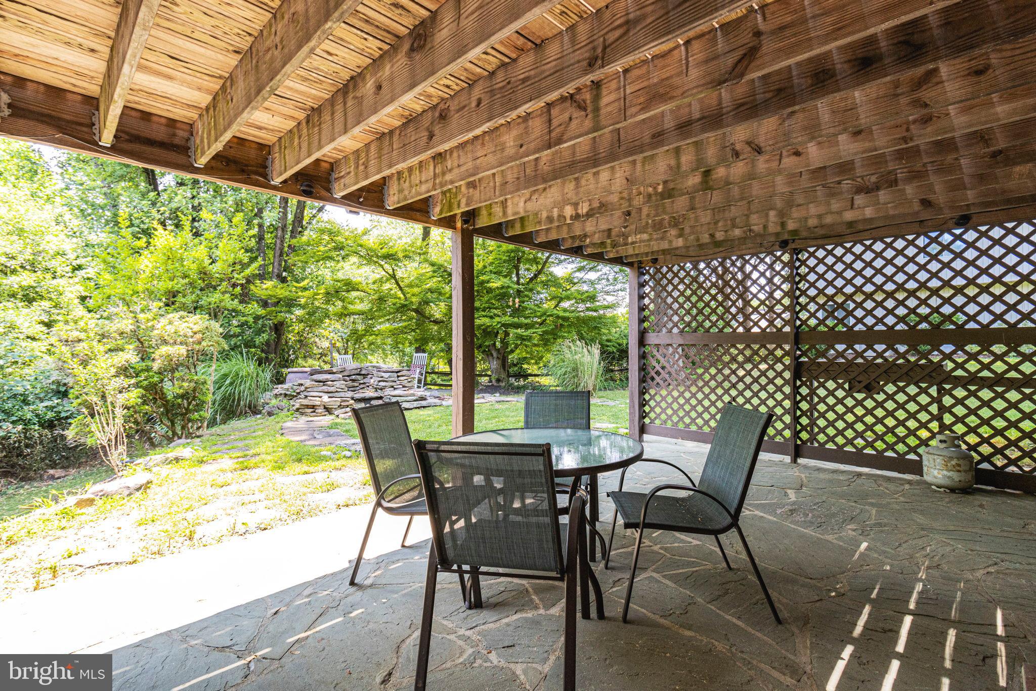 9712 Eldwick Way Potomac, MD 20854 - Photo 42 of 63 a view of a patio with table and chairs and wooden floor