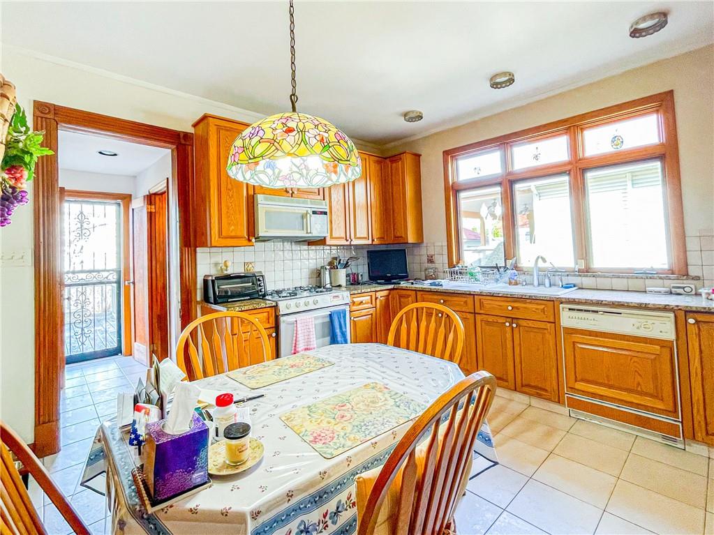 247 82nd Street Brooklyn, NY 11209 - Photo 24 of 48 a very nice looking kitchen with granite countertop a stove a sink a dining table and chairs