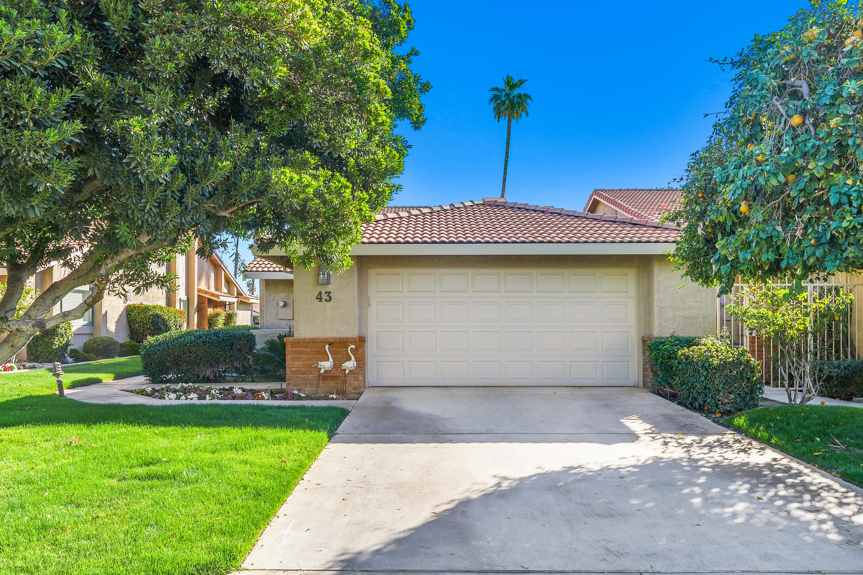 43 Conejo Circle Palm Desert, CA 92260 - Photo 32 of 58 a front view of a house with a garden