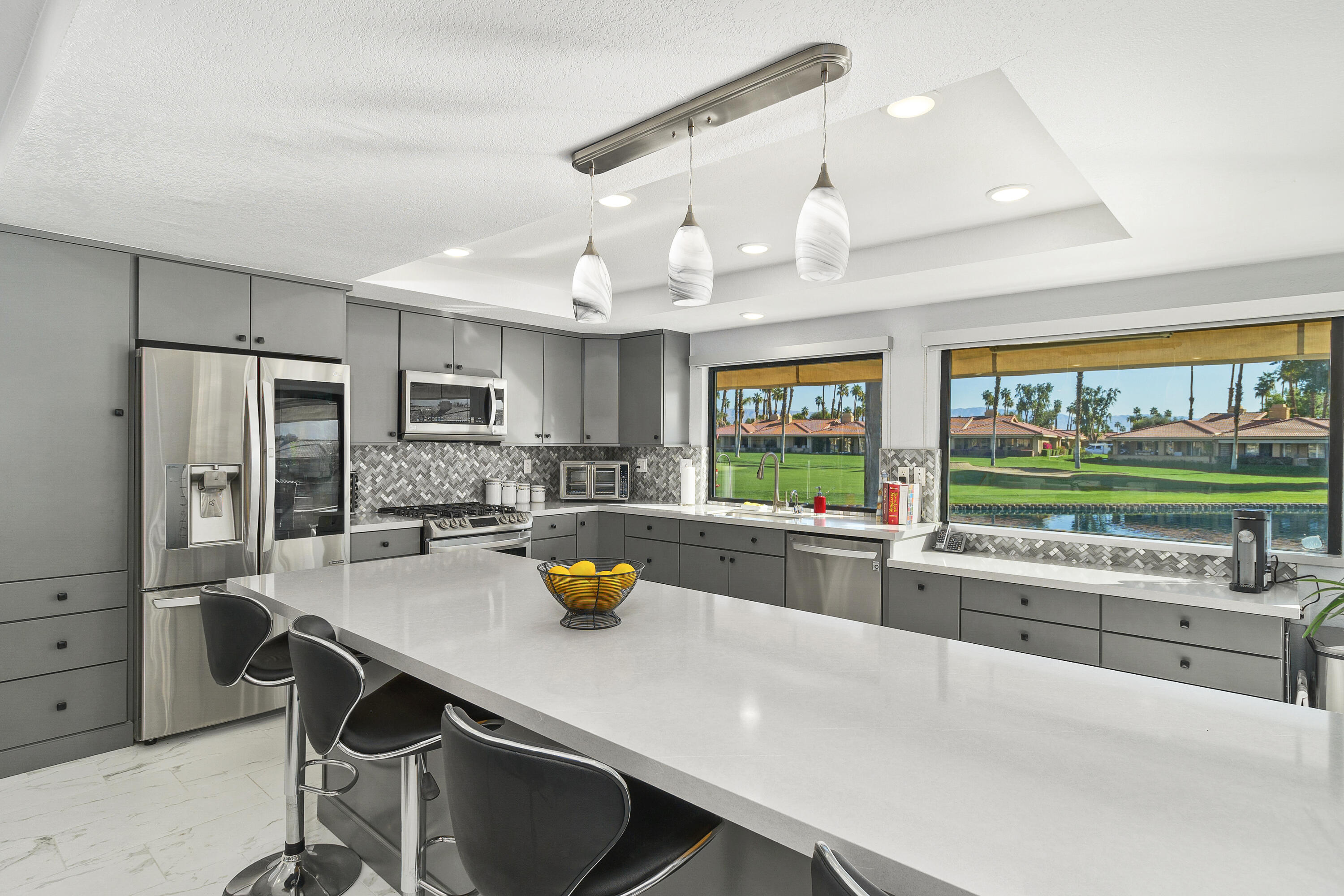 43 Conejo Circle Palm Desert, CA 92260 - Photo 5 of 58 a kitchen with a sink a counter and chairs