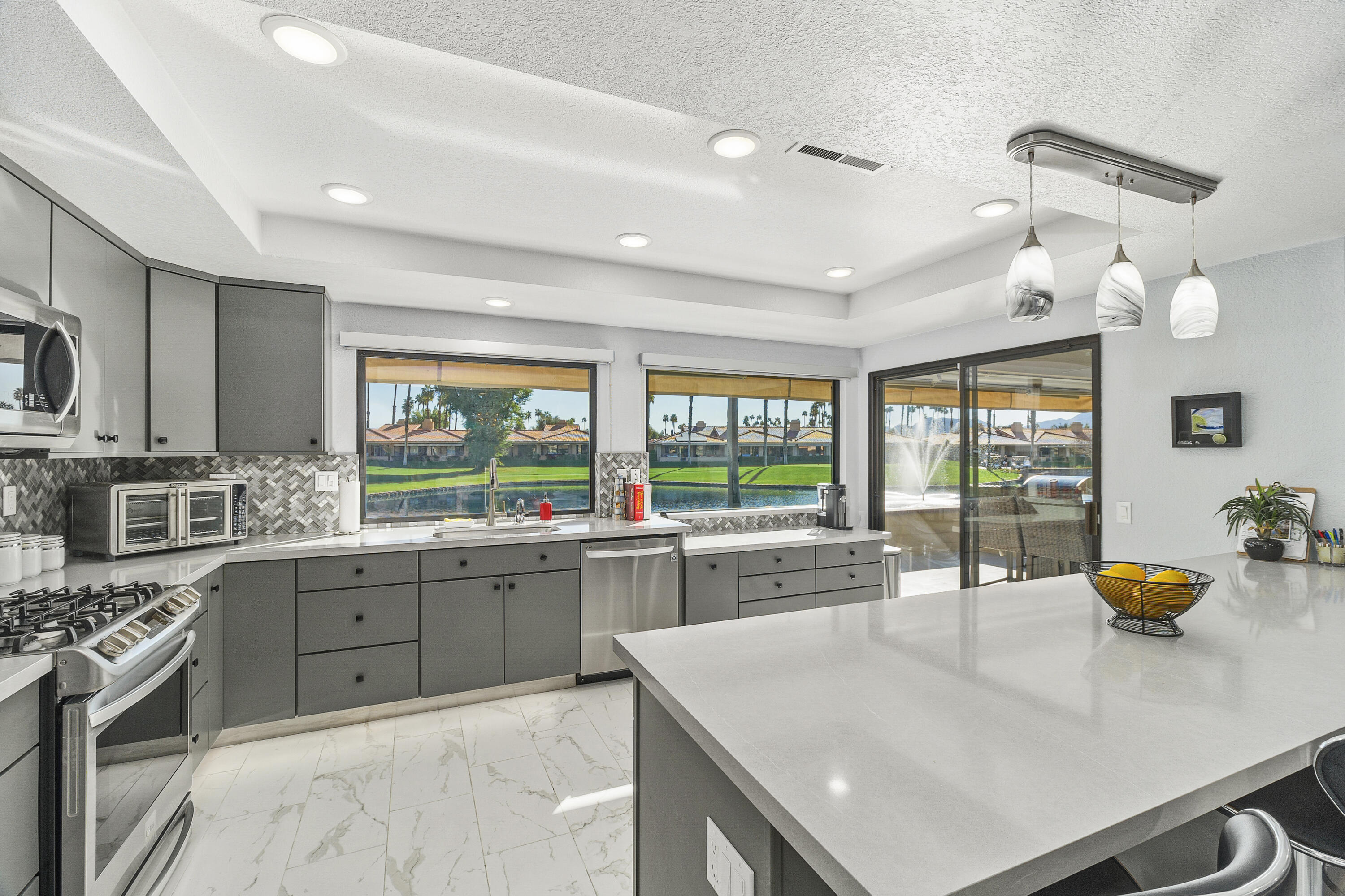 43 Conejo Circle Palm Desert, CA 92260 - Photo 6 of 58 a kitchen with stainless steel appliances granite countertop a sink a stove and a refrigerator