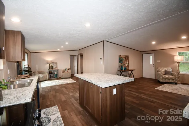a large kitchen with sink a counter top space and stainless steel appliances