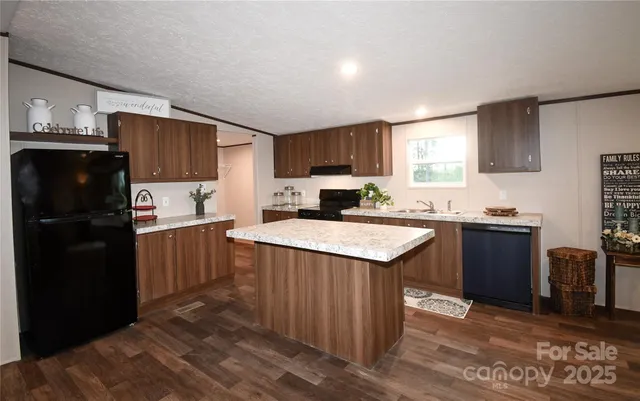 a kitchen with granite countertop a refrigerator stove top oven and sink