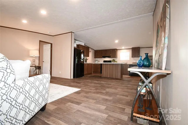 a kitchen with stainless steel appliances kitchen island granite countertop a table chairs in it and wooden floors