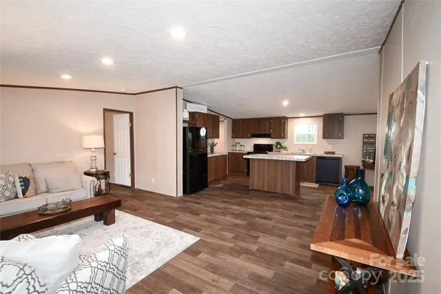 a kitchen with stainless steel appliances kitchen island granite countertop a refrigerator and a sink