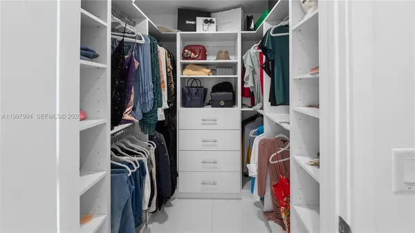 a view of walk in closet with clothes and shoes