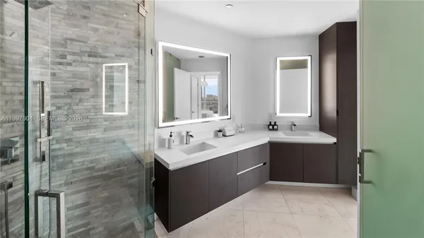 a bathroom with a sink vanity mirror and shower