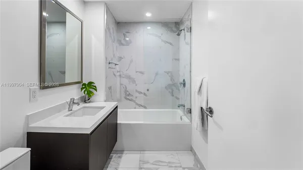 a bathroom with a bathtub a sink and a mirror