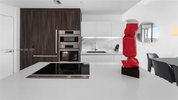 a kitchen with sink and refrigerator