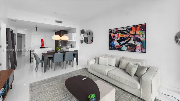 a living room with furniture and kitchen view