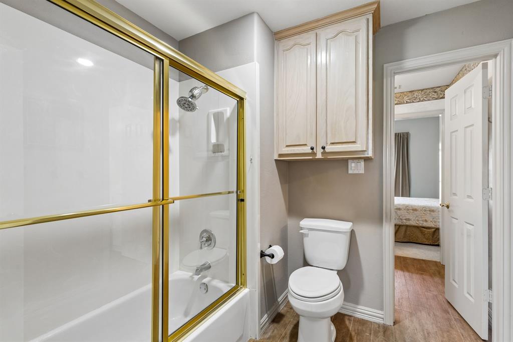 8517 Navigation Drive Rowlett, TX 75088 - Photo 36 of 39 a bathroom with a granite countertop toilet and a shower