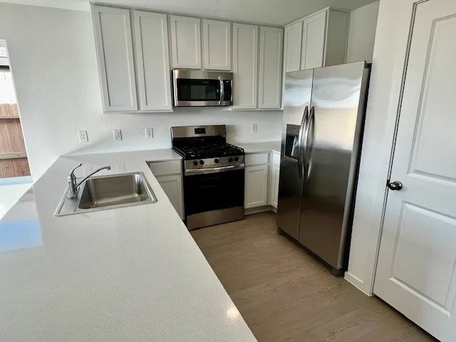 a kitchen with white cabinets and stainless steel appliances