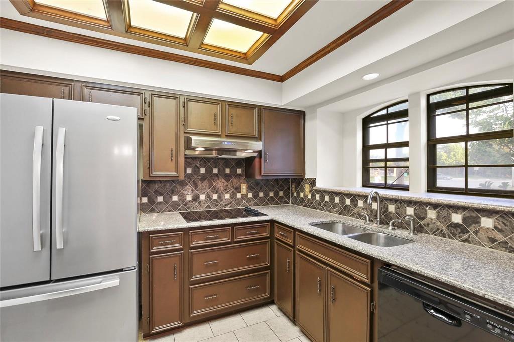 10135 Rita Road Dallas, TX 75243 - Photo 6 of 24 Kitchen with black appliances, light stone countertops, ornamental molding, light tile patterned floors, and tasteful backsplash