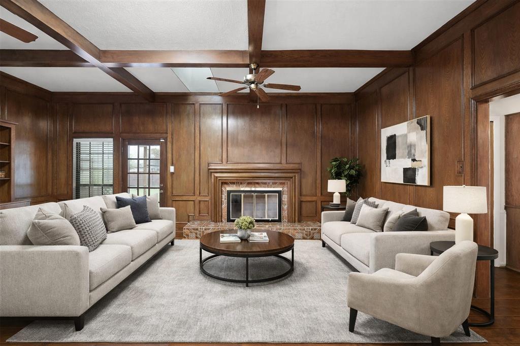 10135 Rita Road Dallas, TX 75243 - Photo 8 of 24 Living area featuring a ceiling fan, wood walls, coffered ceiling, a glass covered fireplace, and wood finished floors