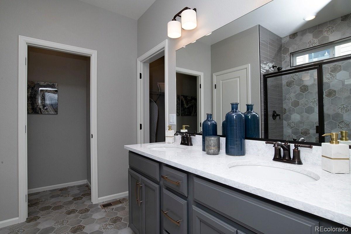 2199 Barela Drive Berthoud, CO 80513 - Photo 20 of 32 a bathroom with double vanity sinks a vanity and a mirror