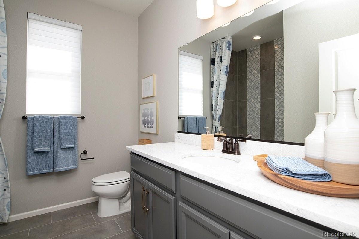 2199 Barela Drive Berthoud, CO 80513 - Photo 22 of 32 a bathroom with a granite countertop sink toilet and mirror