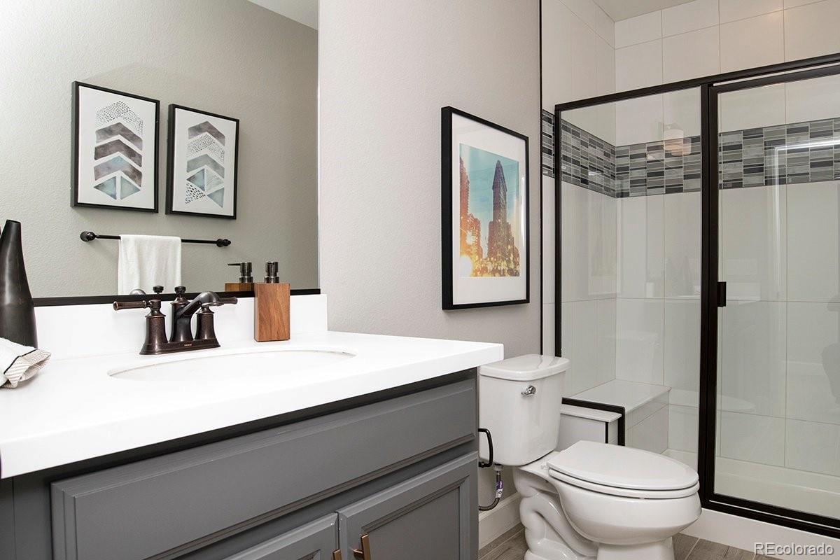 2199 Barela Drive Berthoud, CO 80513 - Photo 30 of 32 a bathroom with a sink a toilet a mirror and shower