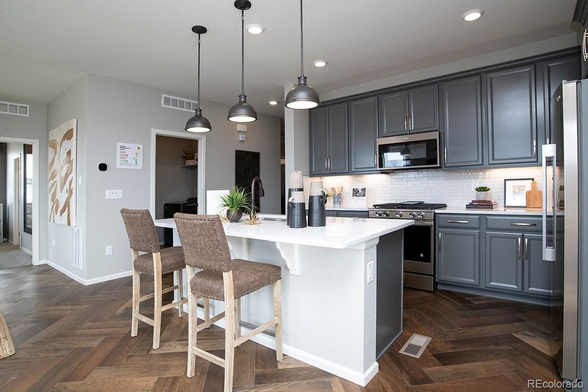 2199 Barela Drive Berthoud, CO 80513 - Photo 9 of 32 a kitchen with kitchen island granite countertop a sink a counter space appliances and cabinets