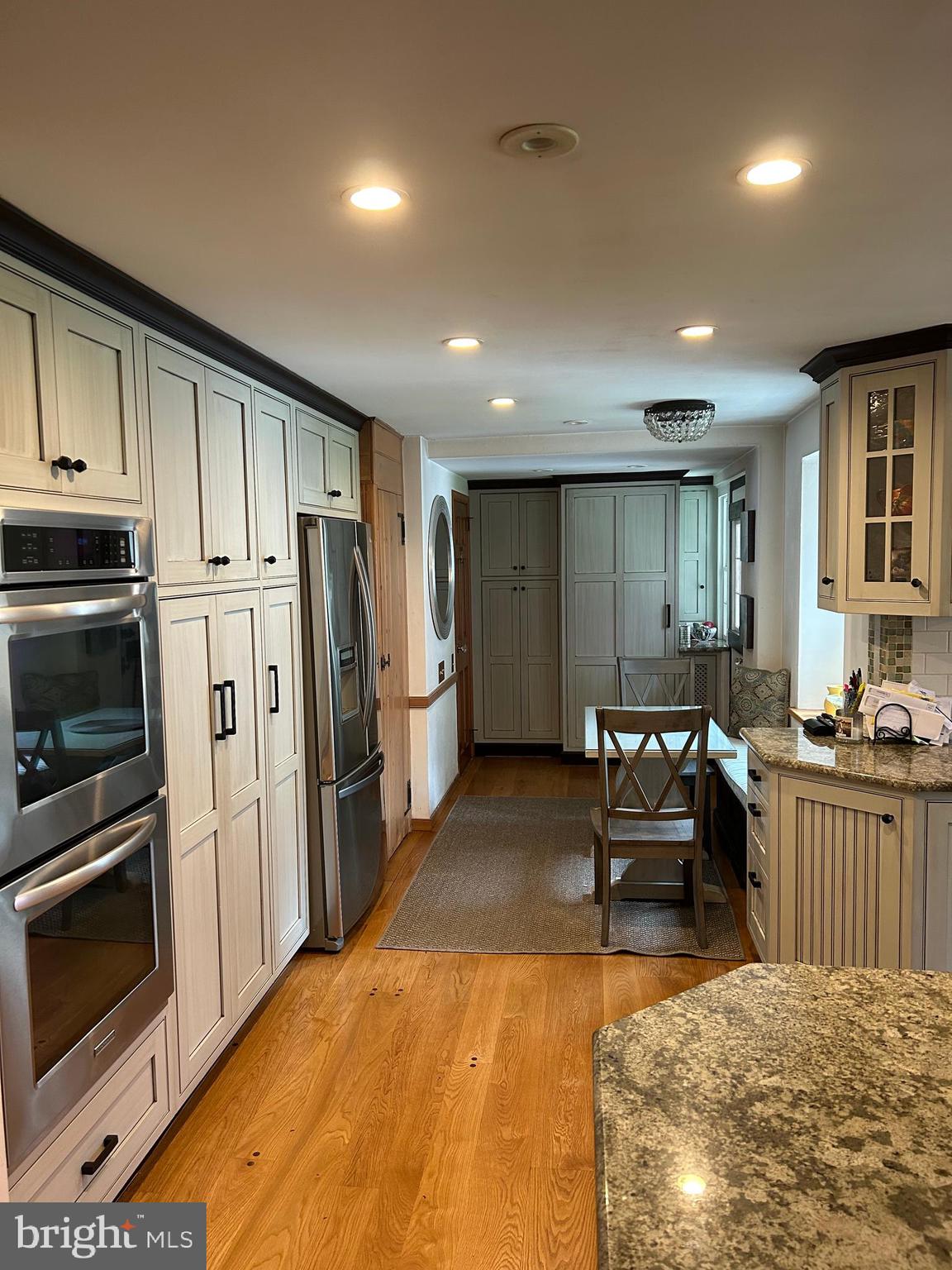 1521 Old Welsh Road Huntingdon Valley, PA 19006 - Photo 37 of 38 a kitchen with stainless steel appliances kitchen island granite countertop a refrigerator oven stove a dining table and chairs with wooden floor