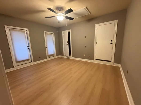 a view of empty room with wooden floor