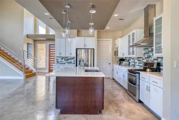 a large kitchen with stainless steel appliances lots of counter space and a refrigerator
