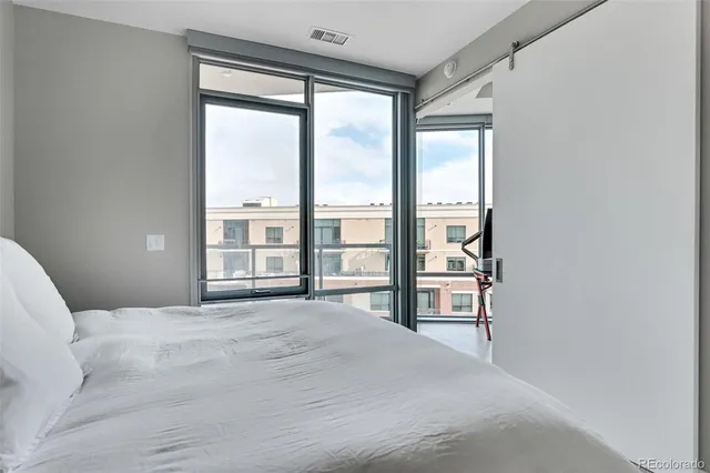 a bedroom with a large bed and a large window with outer view