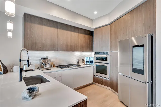 a kitchen with stainless steel appliances a sink a stove a refrigerator and cabinets