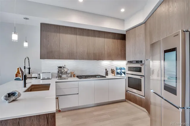 a kitchen with stainless steel appliances granite countertop a sink stove and refrigerator