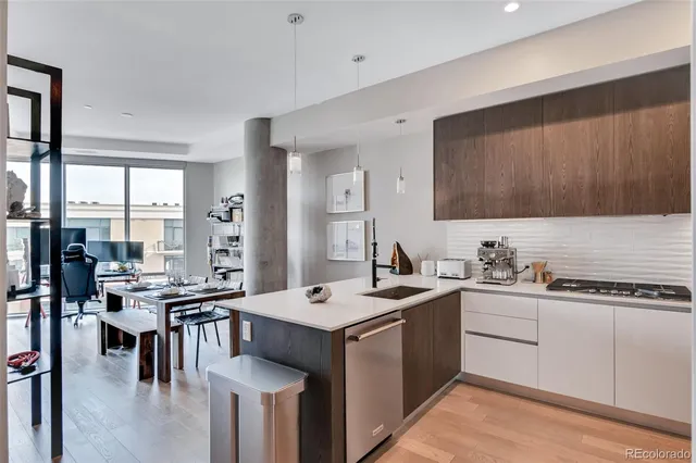 a kitchen that has a sink a table and chairs in it