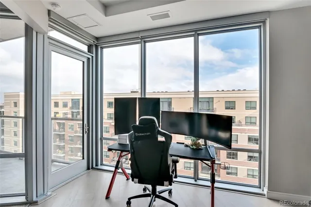 a view of a workspace with furniture and a window
