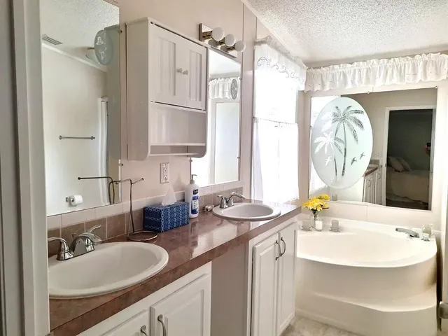 a bathroom with double vanity sinks and a mirror