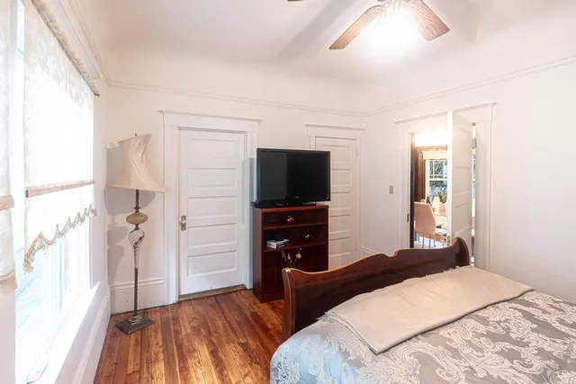 a bedroom with a bed and a flat tv screen on wall