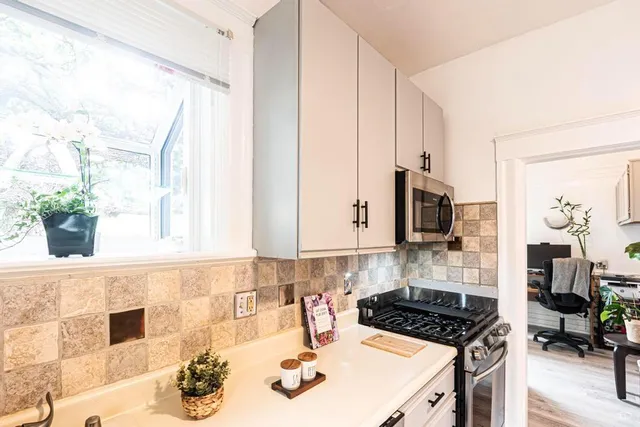 a kitchen with a sink a stove and a window