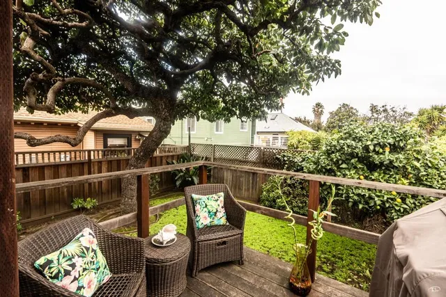 a view of a balcony with chairs potted plants with wooden floor